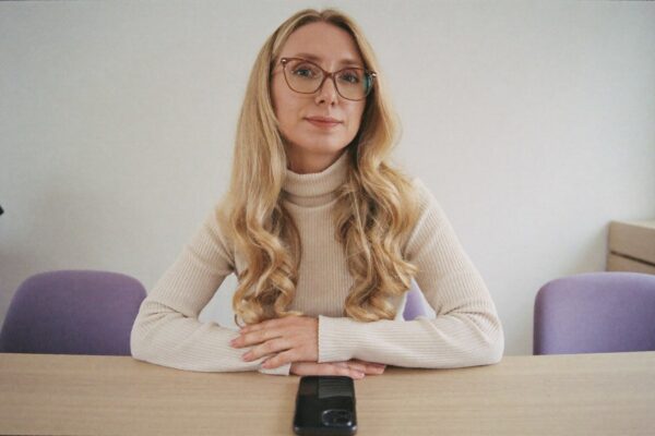 Danusia Pałubicka-Stenka przy stole, smartfon leżący przed nią