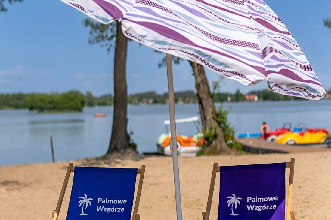 Leżaki i parasol na plaży nad jeziorem